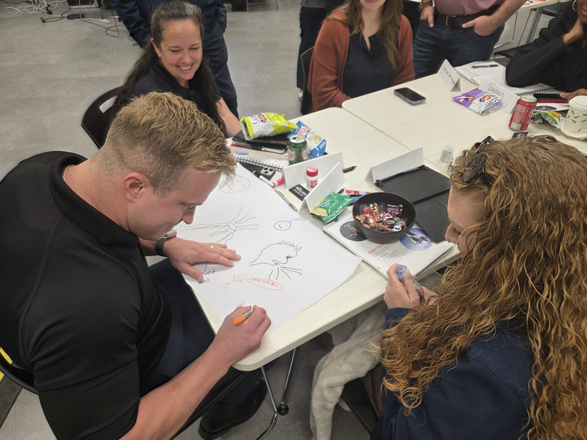 Team members collaborating on a creative drawing exercise